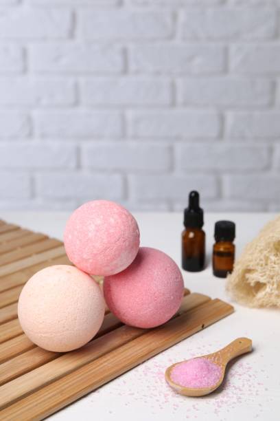 istock Beautiful aromatic bath bombs and sea salt on white table, space for text 1928989736