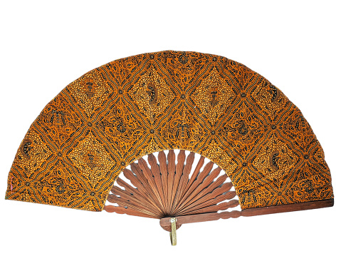 A traditional hand fan with a batik pattern isolated on a white background.