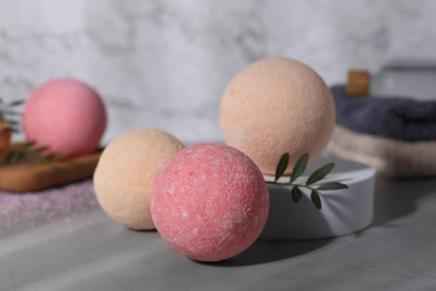 istock Beautiful aromatic bath bombs and green twig on grey table 1928989742