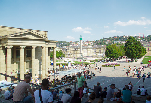 Stuttgart, Baden-Wuerttemberg, Germany, Europe - August 14, 2021 - Small Palace Square Blue Sky Summer Cityscape, Koenigsbau Passagen Shopping Mall (2006) in the Foreground, Palace Square with Concordia Jubilee Column (1841) and New Palace (1807) in the Background, Stuttgart-Mitte Stuttgart-Center District, Stuttgart Historic City Center, Southern Germany, Western Europe