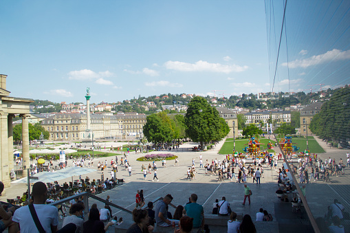 Stuttgart, Baden-Wuerttemberg, Germany, Europe - August 14, 2021 - Small Palace Square Blue Sky Summer Cityscape, Koenigsbau Passagen Shopping Mall (2006, Left) and Kunstmuseum Stuttgart (2005, Right) in the Foreground, Palace Square with Concordia Jubilee Column (1841) and New Palace (1807) in the Background, Stuttgart-Mitte Stuttgart-Center District, Stuttgart Historic City Center, Southern Germany, Western Europe