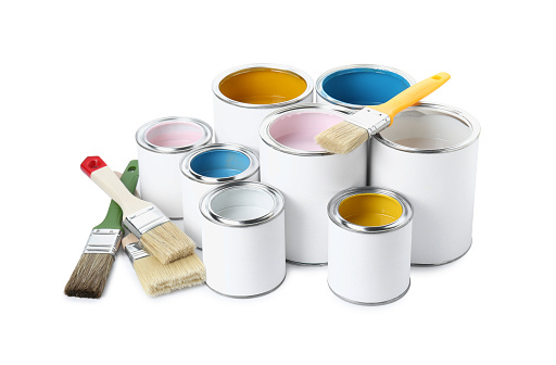 Metal paint cans and paint brushes on multicolor background. Top view. Copy space. Trendy green color concept.