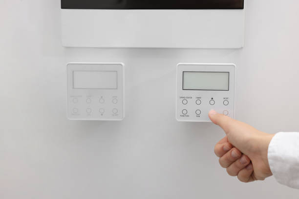 istock Woman adjusting thermostat on white wall, closeup. Smart home system 1929007529