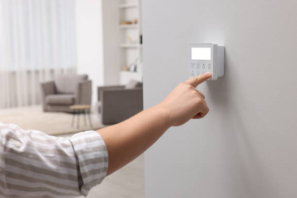 istock Man adjusting thermostat on white wall indoors, closeup. Smart home system 1929007543