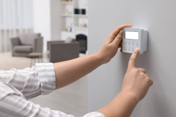 istock Man adjusting thermostat on white wall indoors, closeup. Smart home system 1929009116