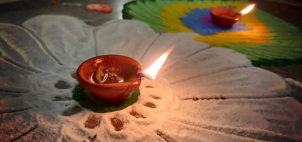 Happy Diwali - - Lighted deepak decorated over rangoli. Apt for Diwali, Durga pooja, Navratri, Ganesh Chaturthi, Onam, Navratri, Inauguration, housewarming related greeting cards, posters, backdrops and wallpapers. There is No people and no text.