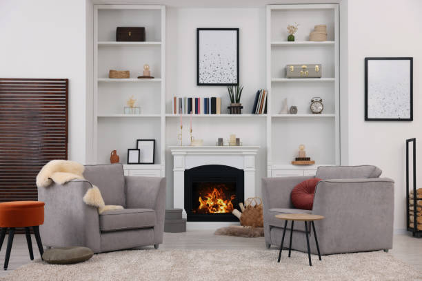 istock Comfortable armchairs, fireplace and shelves in living room. Interior design 1929066485