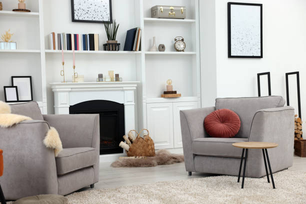 istock Comfortable armchairs, fireplace and shelves in living room. Interior design 1929067743