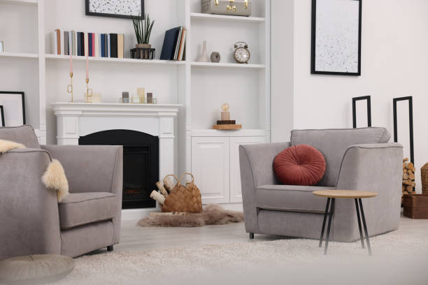 istock Comfortable armchairs, fireplace and shelves in living room. Interior design 1929069040