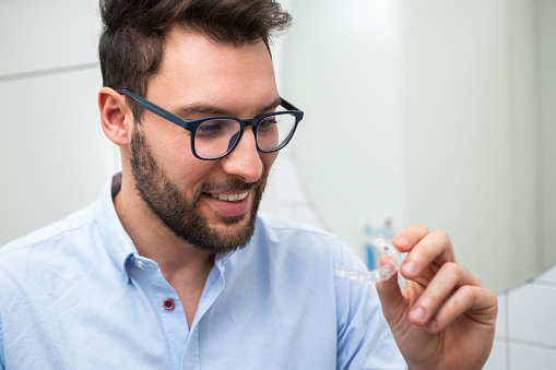 Happy man with transparent dental aligners