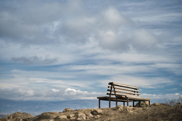 Benches on a mountainside on a hiking trail, mountain view and endless sky with clouds, advertising campaign concept or product mockup with copy space