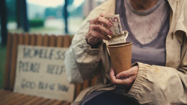 Senior homeless female holding out paper cup, kind person giving money, charity