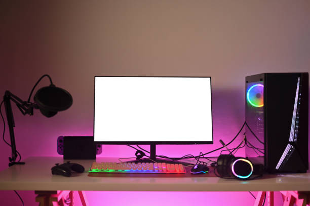 istock Modern gaming computer with mouse, microphone and headphones on table with neon light 1929322825