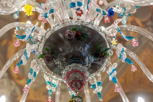A Huge Decorated Glass Chandelier Made In murano, Near Venice, In Italy, On Blurred Background