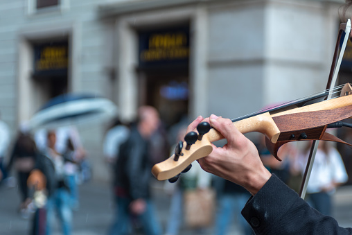Close Up Of A Hand Playing Violin In The Street on Blurred Background