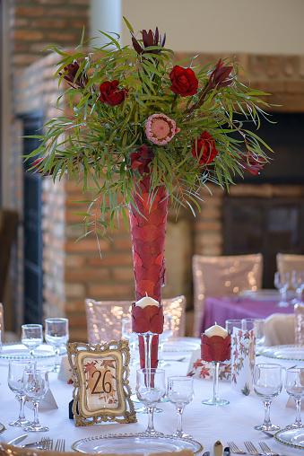 Table arrangement featuring exquisite glassware, beautiful floral arrangements and other refined details for a sit-down meal, elegant and well-coordinated design for a wedding or other special events.