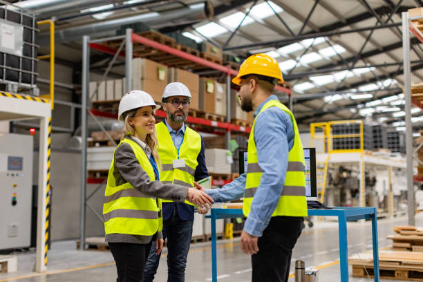 istock Engineers shaking hands with foreman in modern industrial factory, talking about new production project. Team management in manufacturing facility. 1929397025