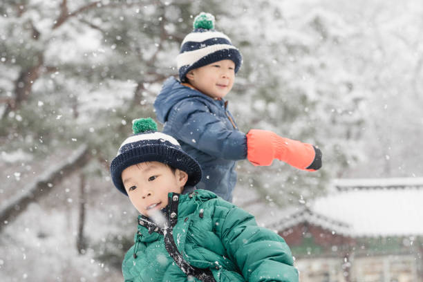 istock Boy's Playful Fun on a Snowy Day in Modern City 1929401222