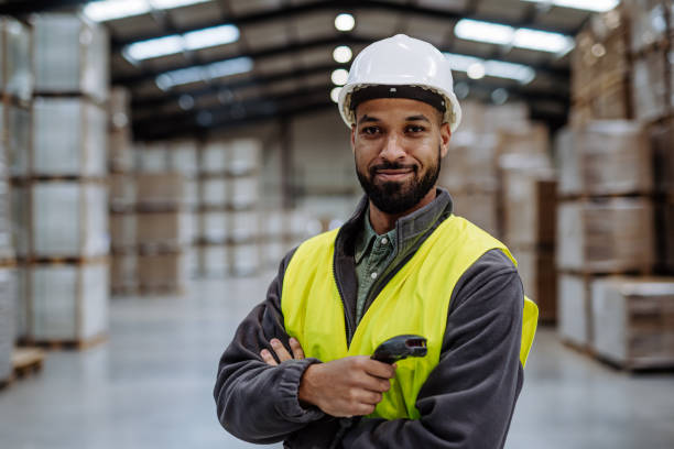 istock Warehouseman with scanner, scanning stock in warehouse. Warehouse manager using warehouse management software, app. 1929422186