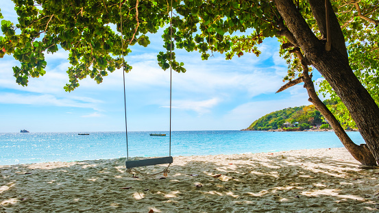Wooden swing on the beach of a tropical island