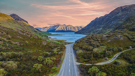 Experience breathtaking aerial views of Lake Hawea from The Neck Lookout in South Island, New Zealand. Discover a serene oasis surrounded by majestic mountains and lush green scenery.