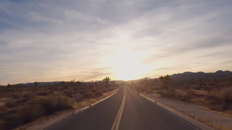 First person perspective of driving along desert road