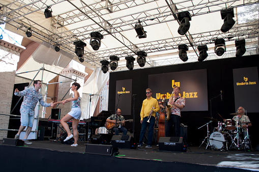 Music group playing a live concert at an outdoor music festival at night in Japan