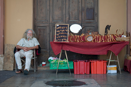 Portrait of a Street Vendor Sleeping Next to His Stall in Perugia, Italy, During a Summer Day