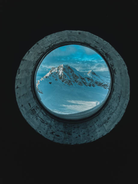 istock Snowy Alps on a sunny day, mountains through the window 1929469259