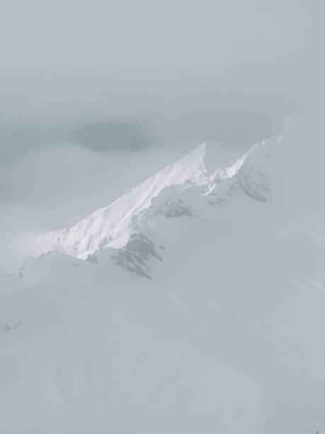 istock Snowy Alps in the clouds on a sunny day, mountains 1929469262