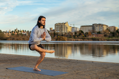 Man Doing Yoga Outdoors. Man Practicing a Balance Pose as Part of His Yoga Training Outdoors.
