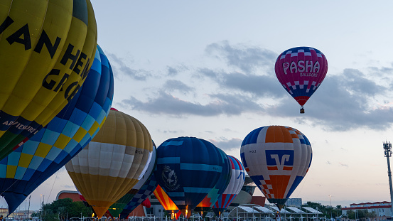 Hot air balloons inflate on field against sky