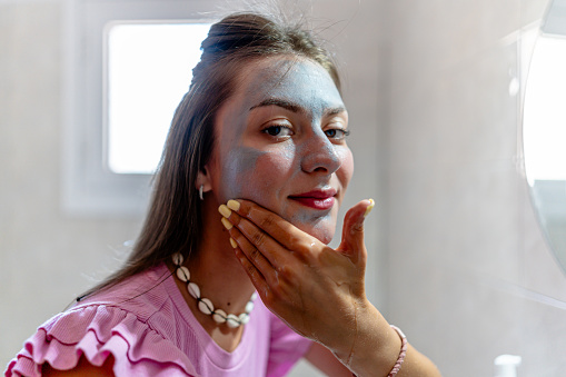 The young woman sets the tone for her day with a revitalizing face mask, ensuring she puts her best face forward