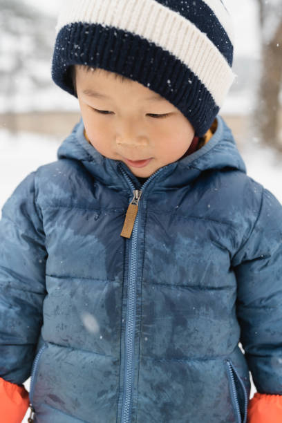 istock Boy's Playful Fun on a Snowy Day in Modern City 1929517089