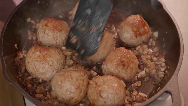making teriyaki pork meatball on a cast iron skillet