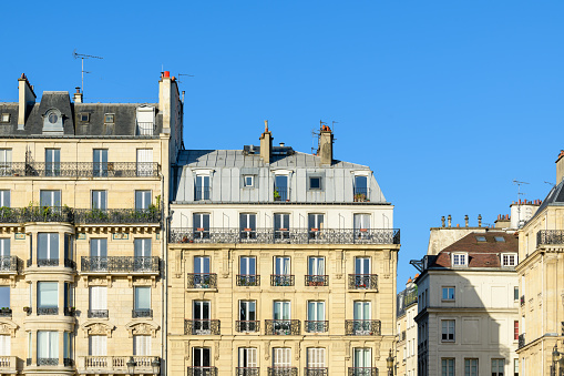 This landscape photo was taken, in Europe, in France, in ile de France, in Paris, in summer. We see the Haussmann Buildings on the ile Saint Louis, under the Sun.