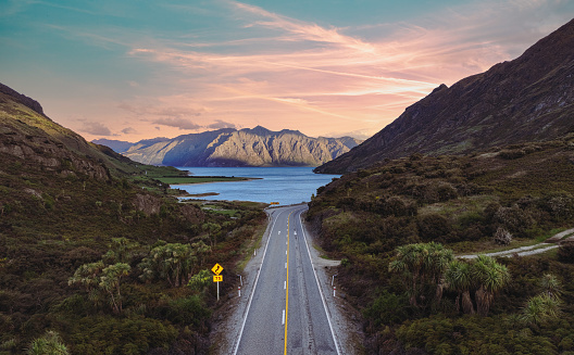 Experience breathtaking aerial views of Lake Hawea from The Neck Lookout in South Island, New Zealand. Discover a serene oasis surrounded by majestic mountains and lush green scenery.