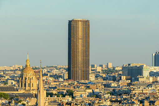 This landscape photo was taken, in Europe, in France, in ile de France, in Paris, in summer. We see the American Cathedral, the Invalides and the Montparnasse tower, under the Sun.
