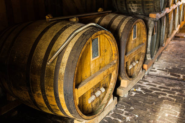 wine or brandy barrels at a winery. stacks of wine or brandy barrels. an old whiskey barrel. an old single malt whisky. - wine barrel cellar sherry stock-fotos und bilder