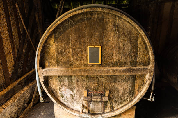 wine or brandy barrels at a winery. stacks of wine or brandy barrels. an old whiskey barrel. an old single malt whisky. - wine barrel cellar sherry stock-fotos und bilder