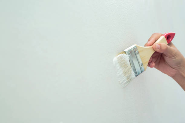 Painter is painting the interior wall white