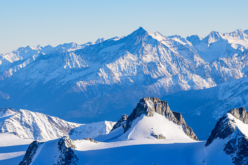 This landscape photo was taken in Europe, in France, Rhone Alpes, in Savoie, in the Alps, in winter. We see Mount Grivola and the Gran Paradiso, under the Sun.