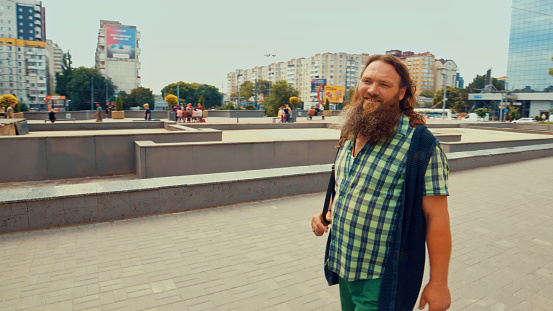 Handsome elderly long-bearded man smiling while walking