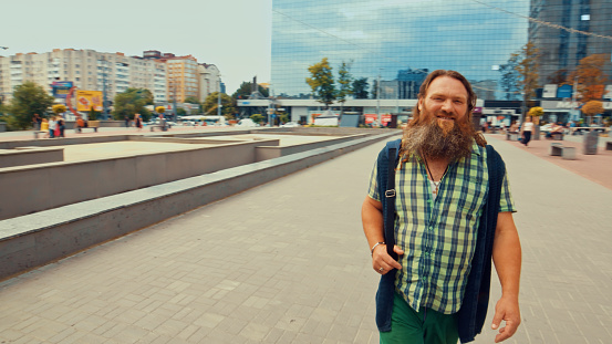 Handsome elderly long-bearded man in a plaid shirt smiling looking at camera
