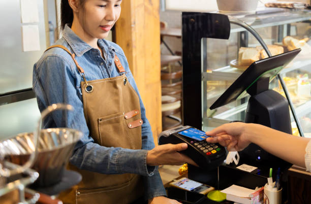 istock Closeup waitress hand holding credit card swipe on wireless digital payment machine, worker wearing apron working in cafe retail small business using modern cashless touchless payment transaction 1929677402