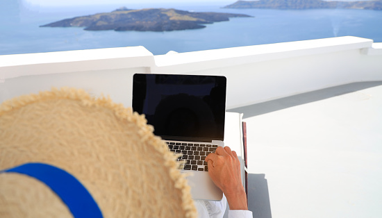 Nomad digital as relaxation of young man  lifestyle with hat  as looking view  in mediterranean  Oia ,Santorini,Greece