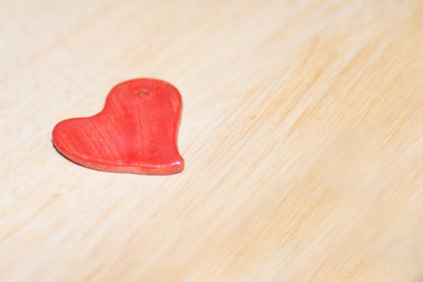 istock Handmade red ceramic heart with wooden background 1929721957