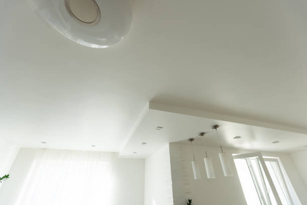 istock suspended ceiling with halogen spots lamps and drywall construction in empty room in apartment or house. Stretch ceiling white and complex shape. 1929739361