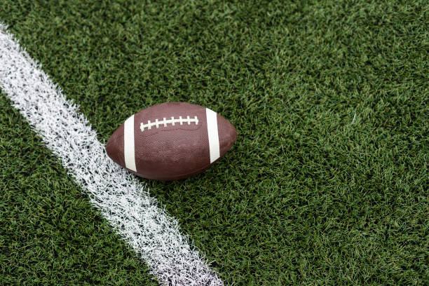 Football by a yard marker on a football field Football by a yard marker on a football field. High quality photo high school soccer stock pictures, royalty-free photos & images