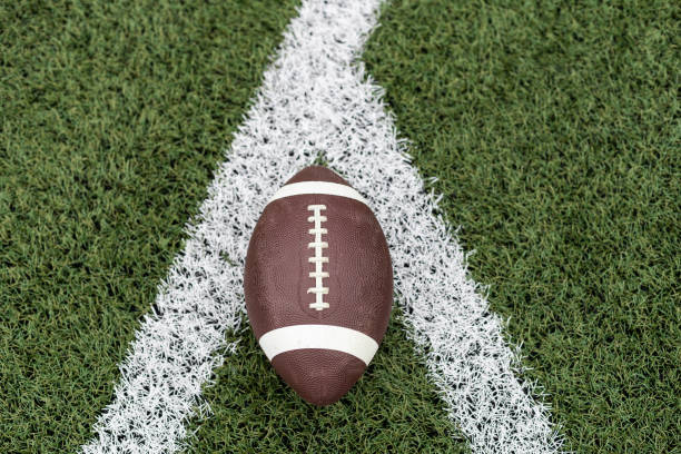 Football on the Field near the Fifty Football on the Field near the Fifty. High quality photo high school soccer stock pictures, royalty-free photos & images